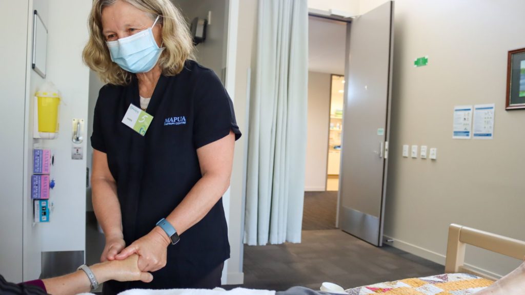 Karen Larsen giving a hand massage to a patient