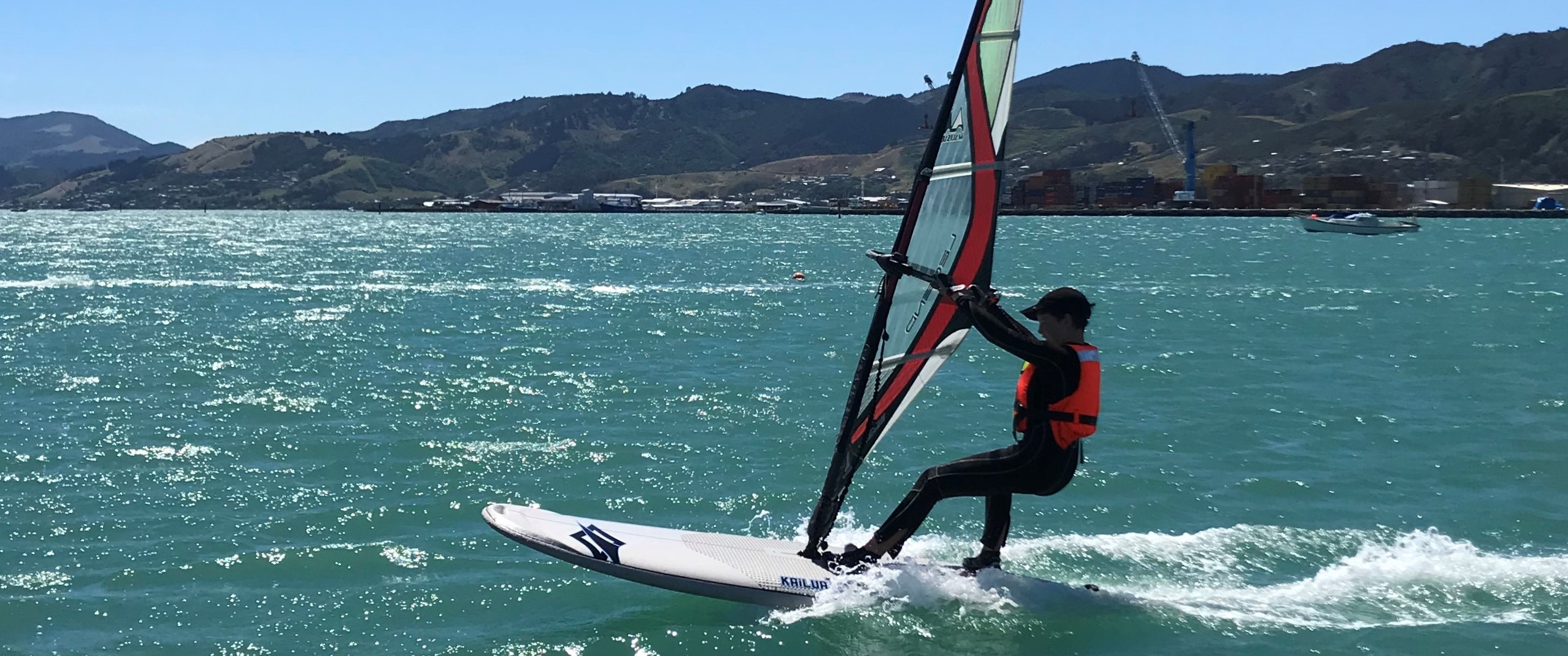 youth windsurfer getting planing in strong winds
