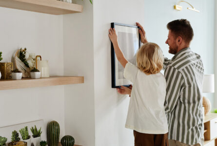 Father And Son Hanging Picture On Wall