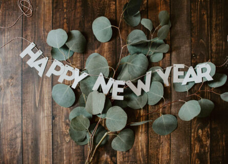 wooden table with leaves and the words Happy New Year